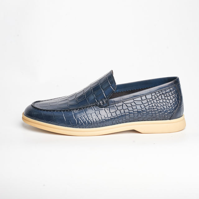 Navy loafer in side profile showing the croc-embossed finish and the sole